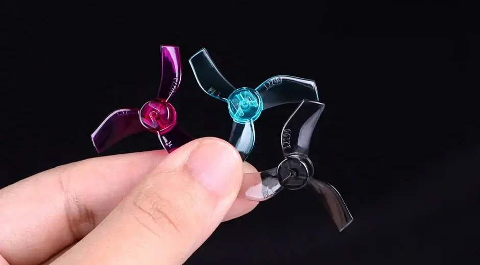 T-Motor M12199 propellers in Clear Purple, Clear Blue and Clear Grey held between fingers